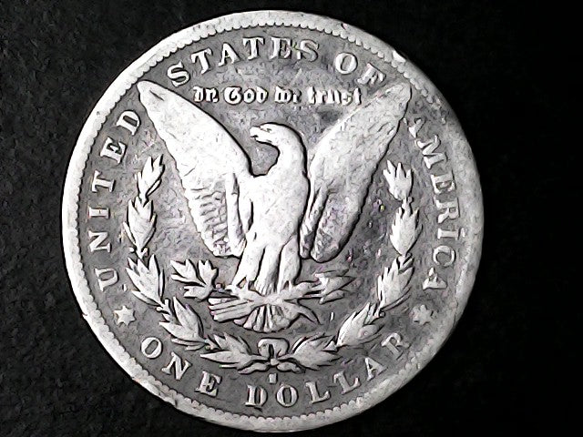 Silver dollar coin with an eagle emblem on a black background