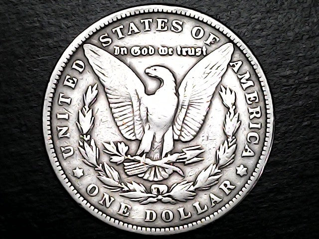 Silver Dollar with an eagle design and 'In God We Trust' inscription on a black background
