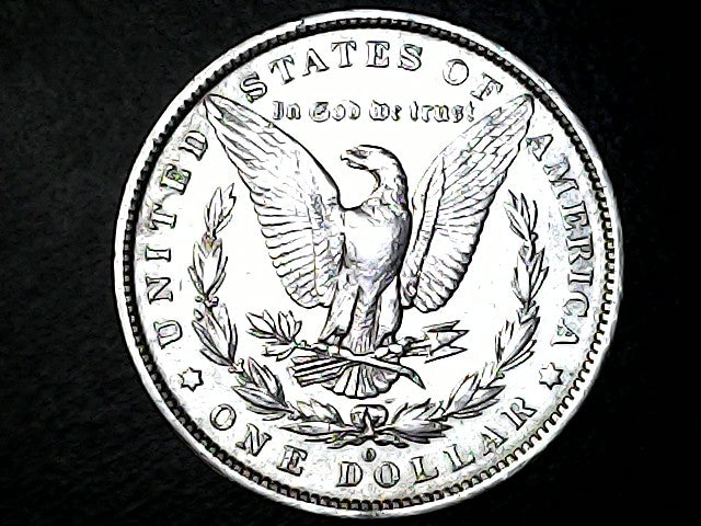 Silver dollar coin with an eagle design on a black background