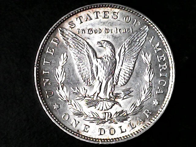 Silver Dollar with an eagle design and 'In God We Trust' inscription on a black background
