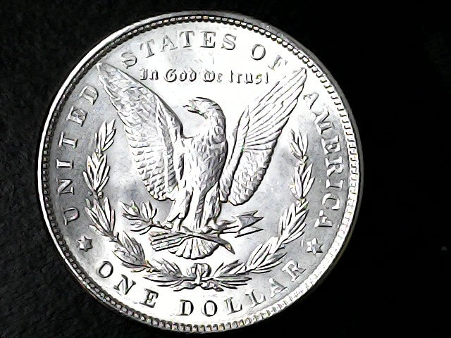 Silver dollar coin with an eagle design on a black background