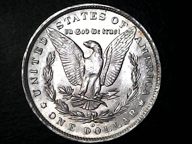 Silver dollar coin with an eagle design on a black background