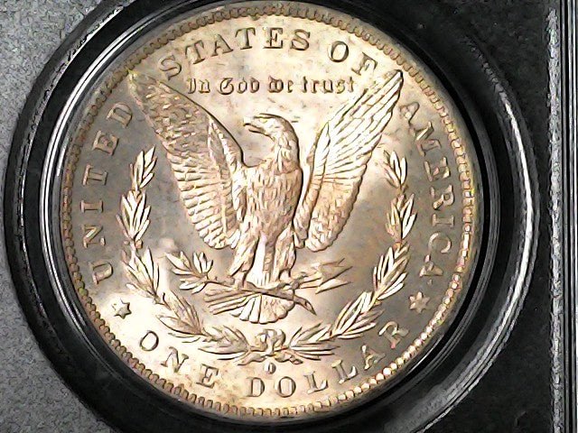 Gold dollar coin with an eagle design in a black holder