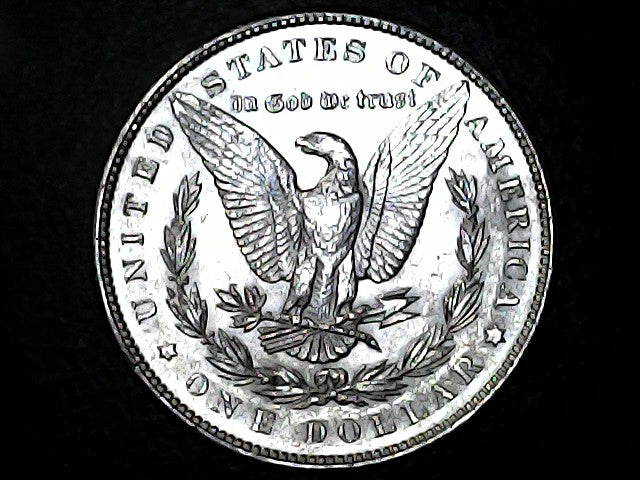 Silver dollar coin with an eagle emblem on a black background