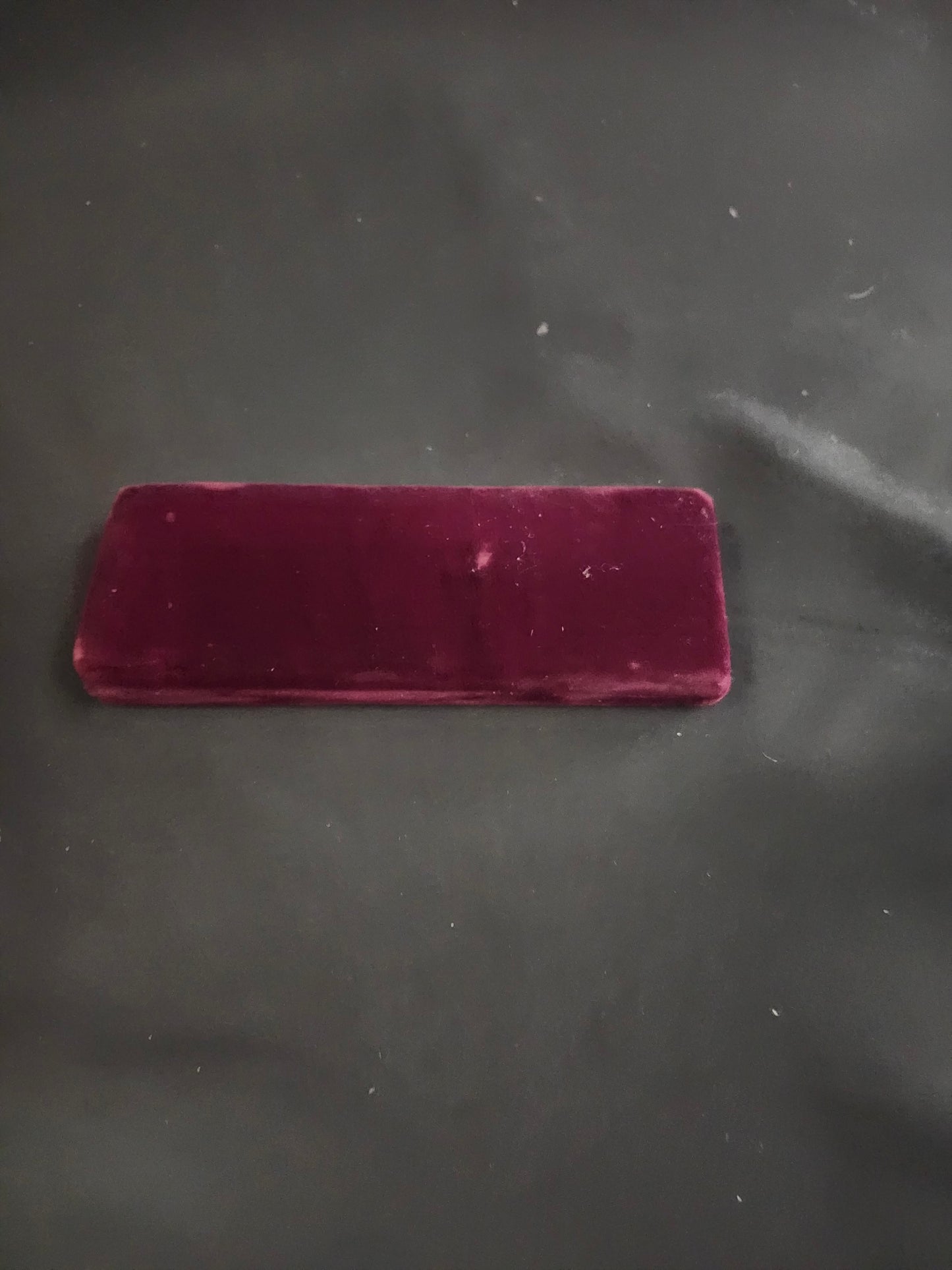 Purple rectangular object on a dark textured surface