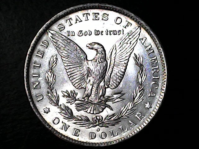 Silver dollar coin with an eagle design on a black background