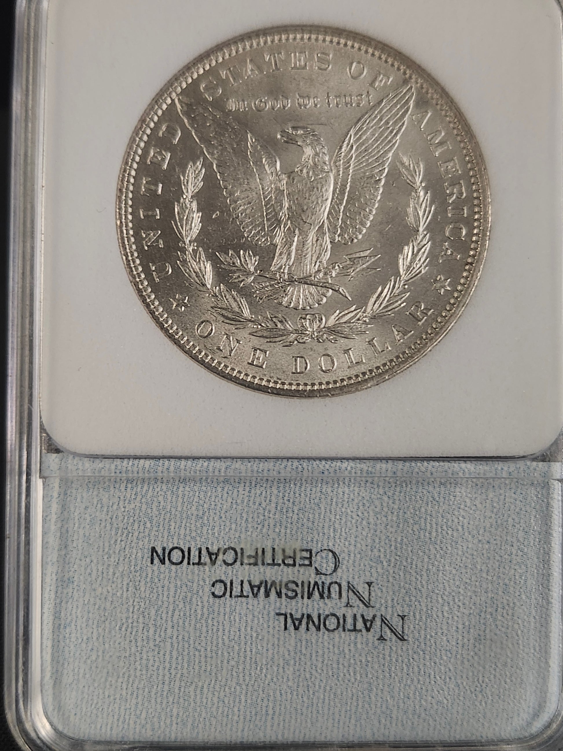 Silver coin with 'National Numismatic Certification' label