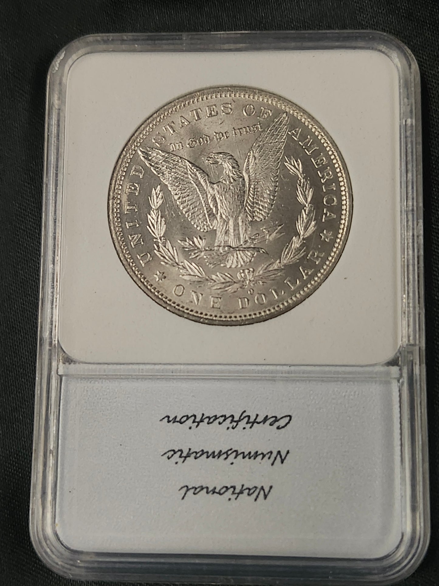Silver coin in a protective case with 'National Numismatic Certification' text
