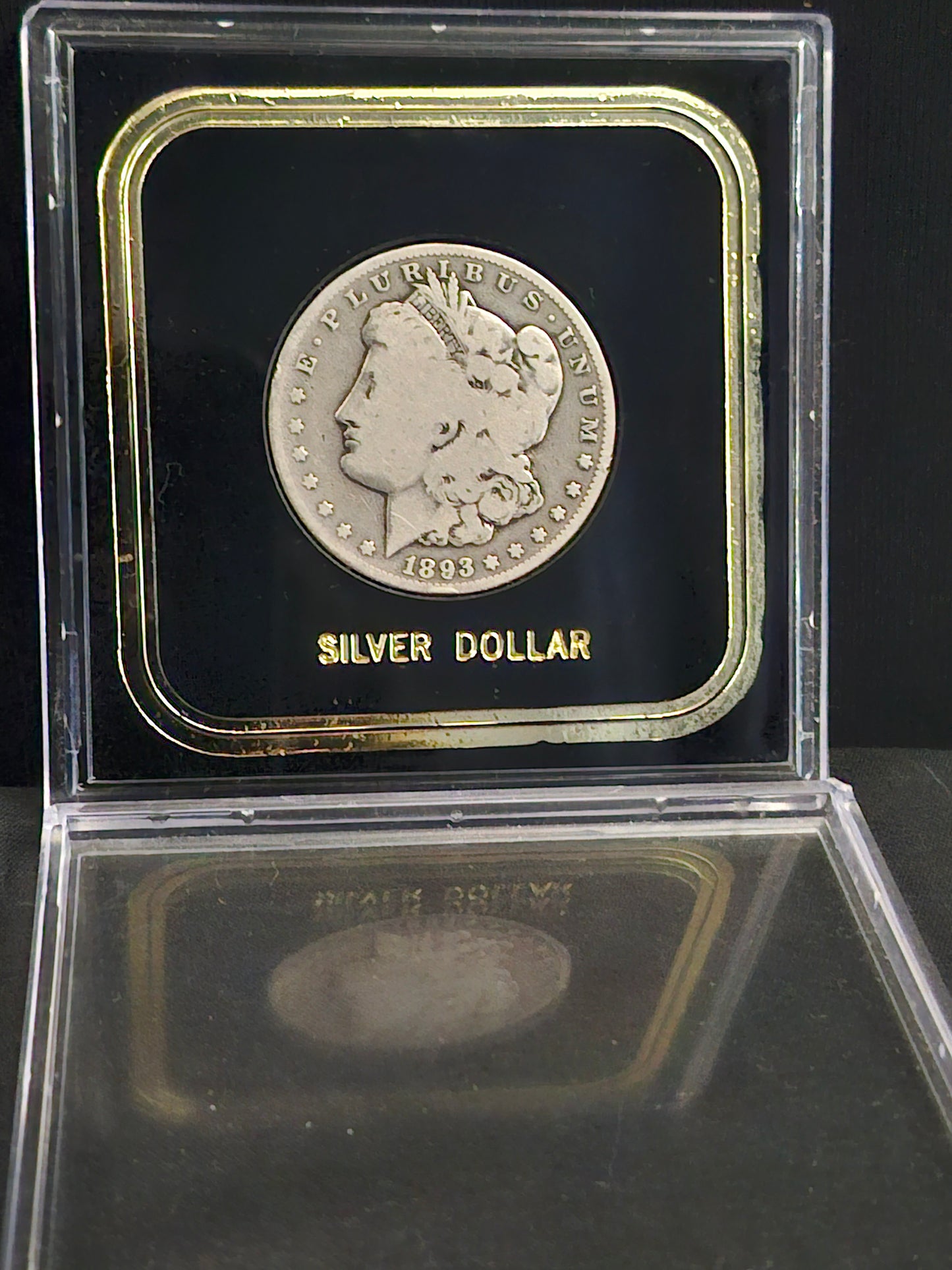 '1893' Morgan Dollar in clear case on black backgoung