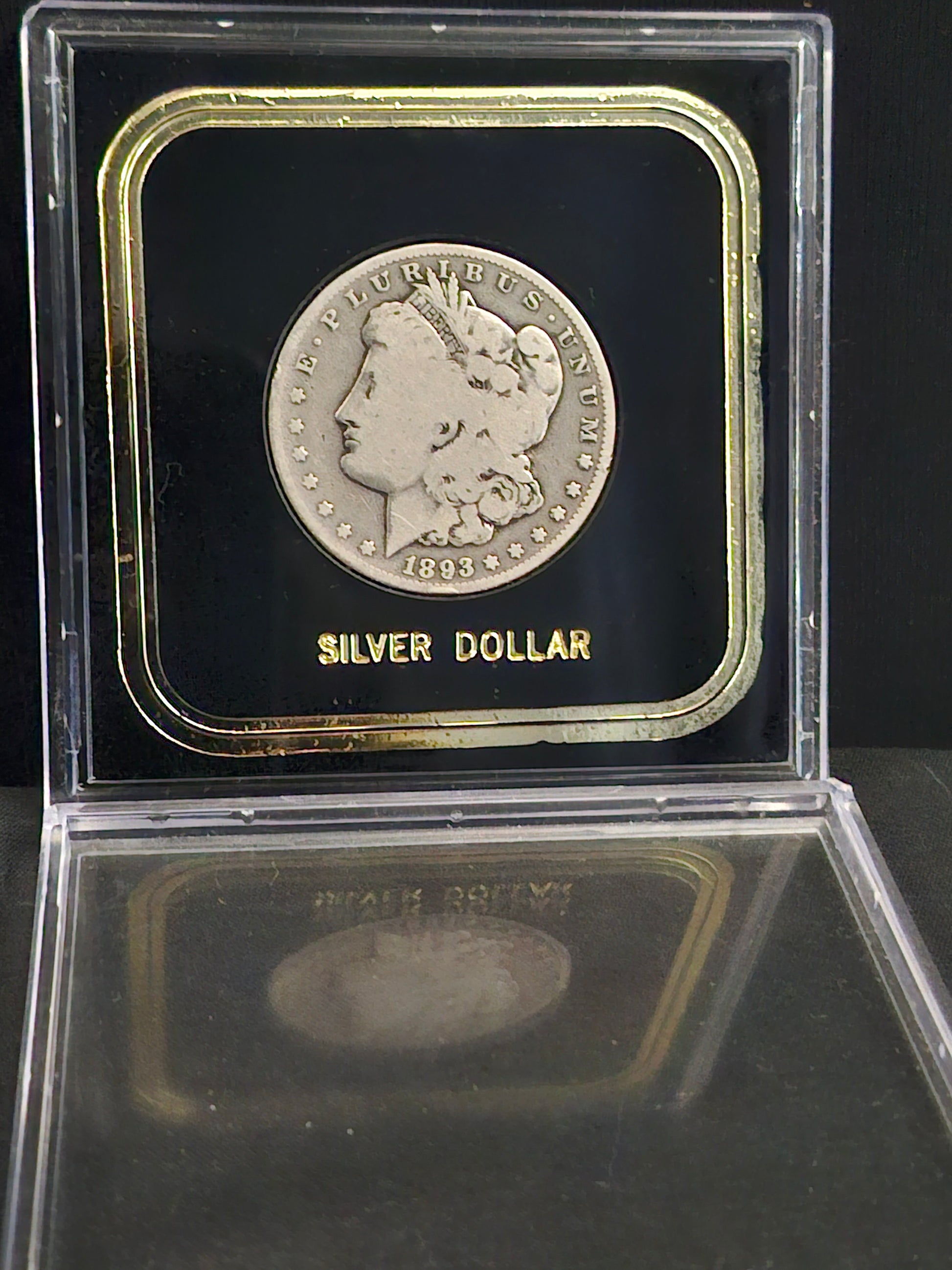 '1893' Morgan Dollar in clear case on black backgoung