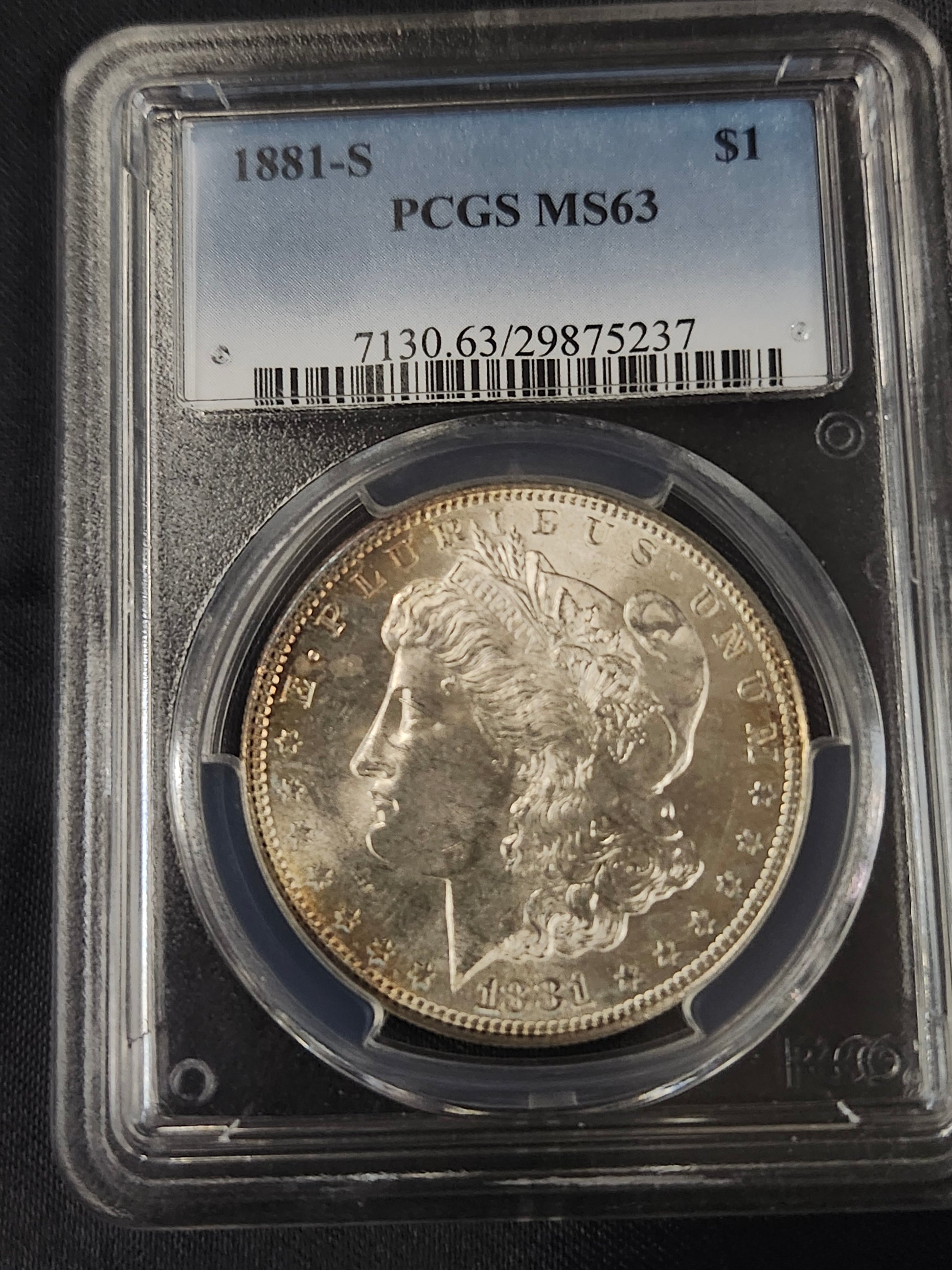 Morgan silver dollar in a protective case with PCGS MS63 grading label.
