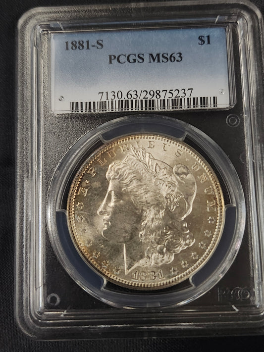 Morgan silver dollar in a protective case with PCGS MS63 grading label.
