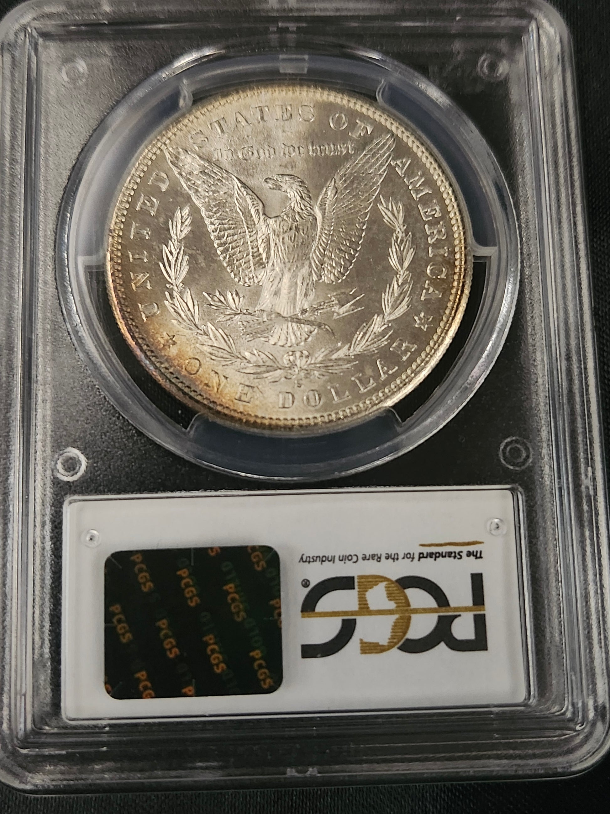 Morgan silver dollar in a protective case with a PCGS label on a black background
