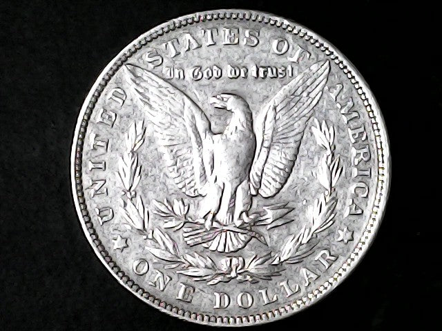 Silver Dollar with an eagle design and 'In God We Trust' inscription on a black background