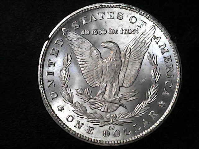 Silver Dollar with an eagle design, 'In God We Trust' and "CC" inscription on a black background