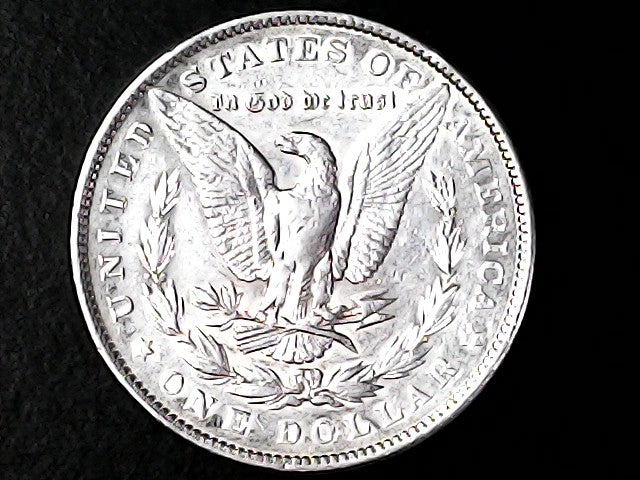 Silver dollar coin with an eagle design on a black background