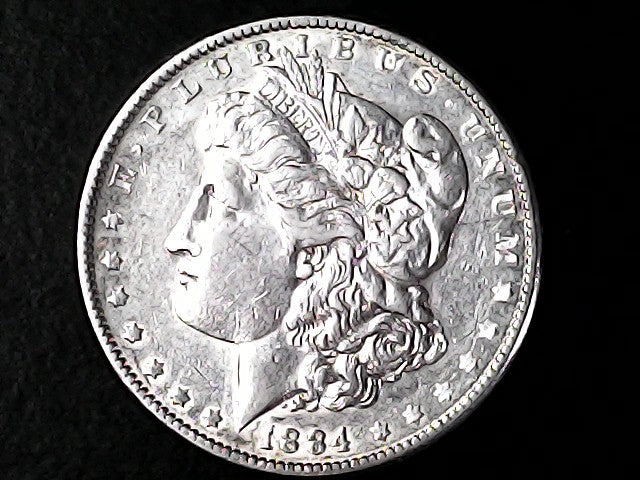 Silver coin with a profile of a person and 'LIBERTY' text on a black background