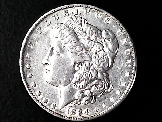 Silver coin with a profile of a person and 'LIBERTY' text on a black background