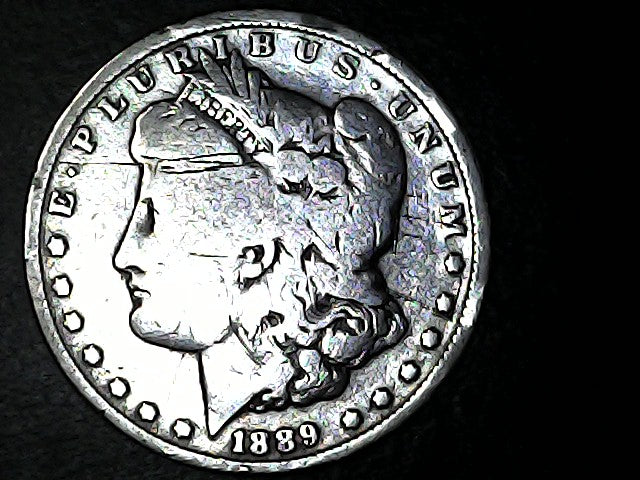 Silver Morgan Dollar with 'E Pluribus Unum', 'Liberty'  and '1889' inscriptions on a black background