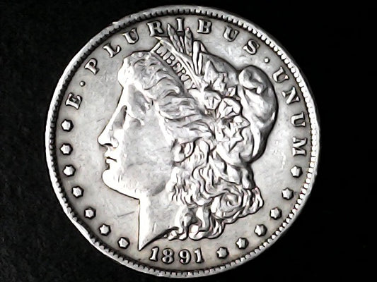 Silver Morgan dollar coin with 'E Pluribus Unum' and '1891' on a black background