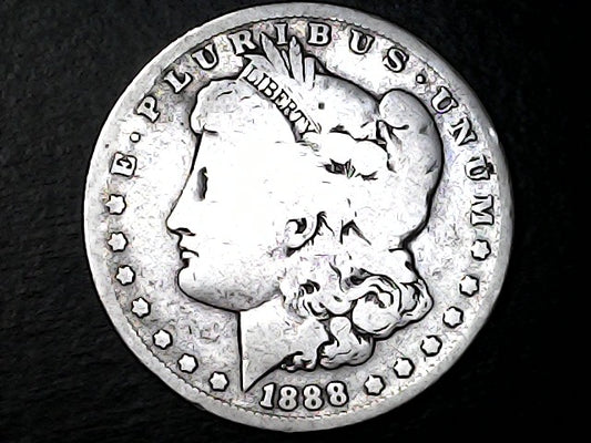 Silver coin with a profile of a head and 'P. PLURIBUS UNUM' text and '1888' on a dark background