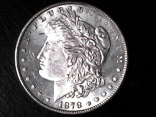 Silver Morgan Dollar Left-facing profile of Liberty wearing a Phrygian cap, with 'LIBERTY', "E PLURIBUS UNUM" and '1878' inscriptions on a black background with case