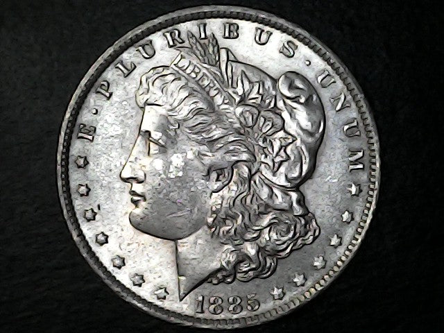 Silver Morgan Dollar Left-facing profile of Liberty wearing a Phrygian cap, with 'LIBERTY', "E PLURIBUS UNUM" and '1885' inscriptions on a black background with case