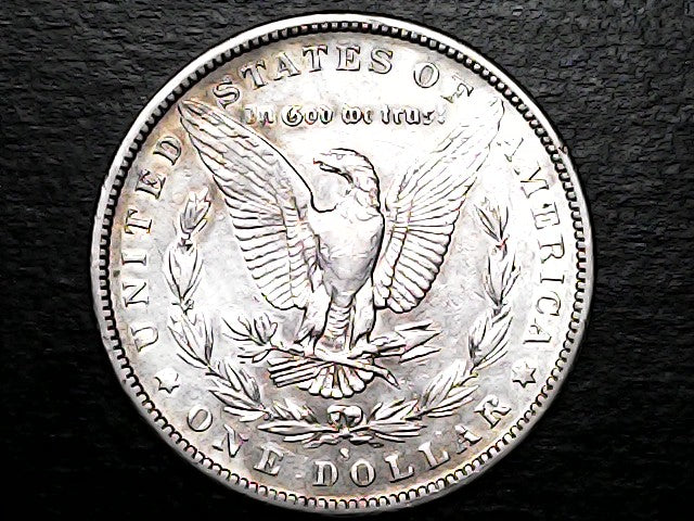 Silver dollar coin with an eagle design on a black background