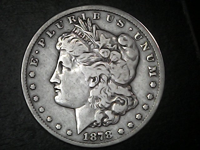 Silver Morgan Dollar Left-facing profile of Liberty wearing a Phrygian cap, with 'LIBERTY', "E PLURIBUS UNUM" and '1878' inscriptions on a black background with case