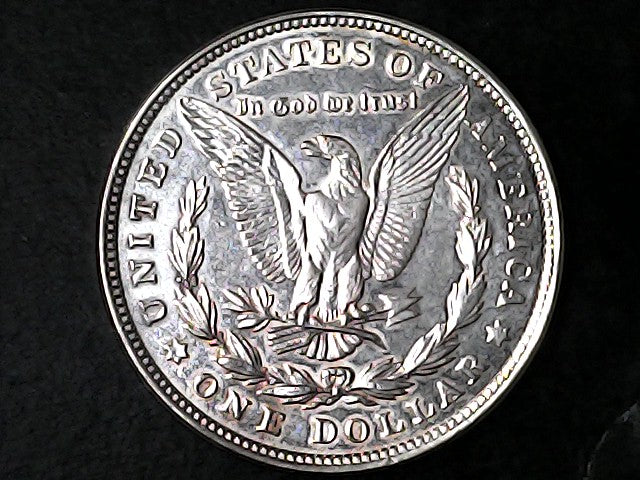 Silver Dollar with an eagle design and 'In God We Trust' inscription on a black background