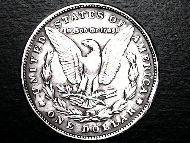Silver Dollar with an eagle design and 'In God We Trust' inscription on a black background