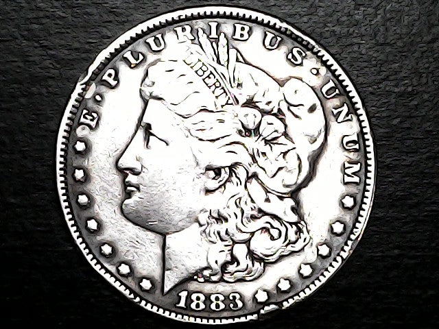 Silver Morgan Dollar Left-facing profile of Liberty wearing a Phrygian cap, with 'LIBERTY', "E PLURIBUS UNUM" and '1883' inscriptions on a black background with case