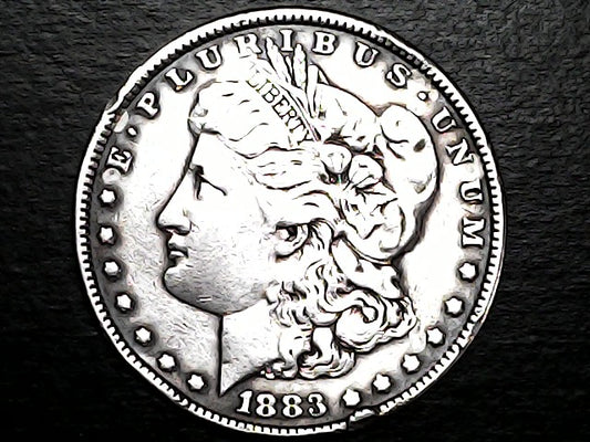 Silver Morgan Dollar Left-facing profile of Liberty wearing a Phrygian cap, with 'LIBERTY', "E PLURIBUS UNUM" and '1883' inscriptions on a black background with case