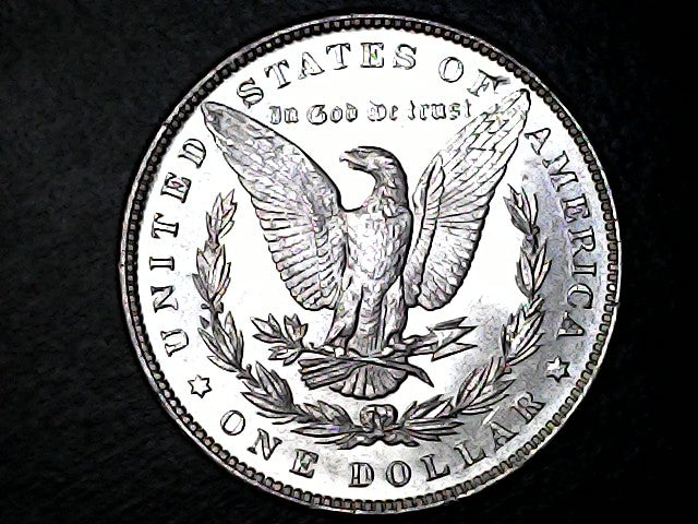 Silver dollar coin with an eagle design on a black background