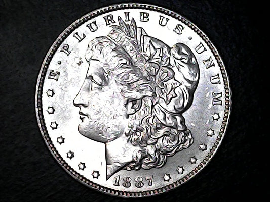 Silver Morgan dollar coin with 'E Pluribus Unum' and '1887' on a dark background