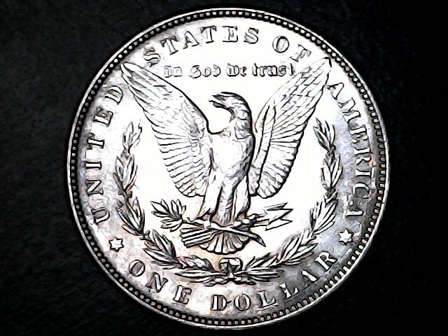 Silver dollar coin with an eagle emblem on a black background