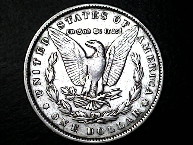 Silver dollar coin with an eagle emblem on a black background