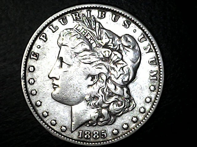 Silver Morgan dollar coin from 1885 with detailed design on a black background