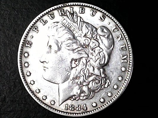 Silver coin with a profile of a head and 'E Pluribus Unum' inscription on a dark background