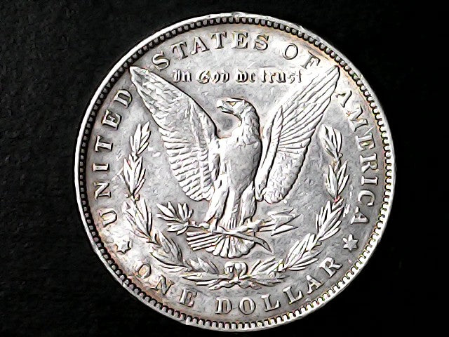 Silver Dollar with an eagle design and 'In God We Trust' inscription on a black background
