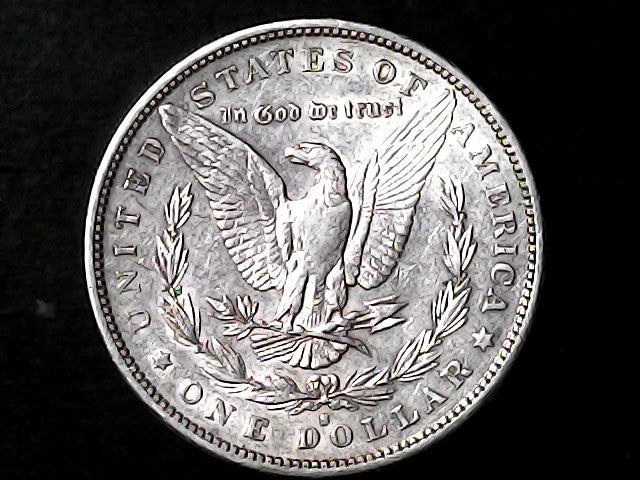 Silver Dollar with an eagle design and 'In God We Trust' inscription on a black background