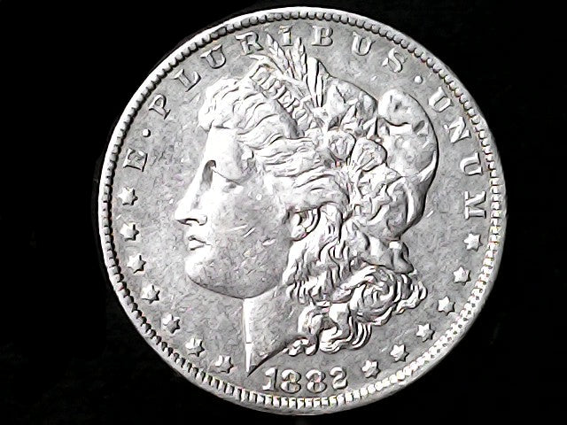 Silver Morgan Dollar Left-facing profile of Liberty wearing a Phrygian cap, with 'LIBERTY', "E PLURIBUS UNUM" and '1882' inscriptions on a black background with case