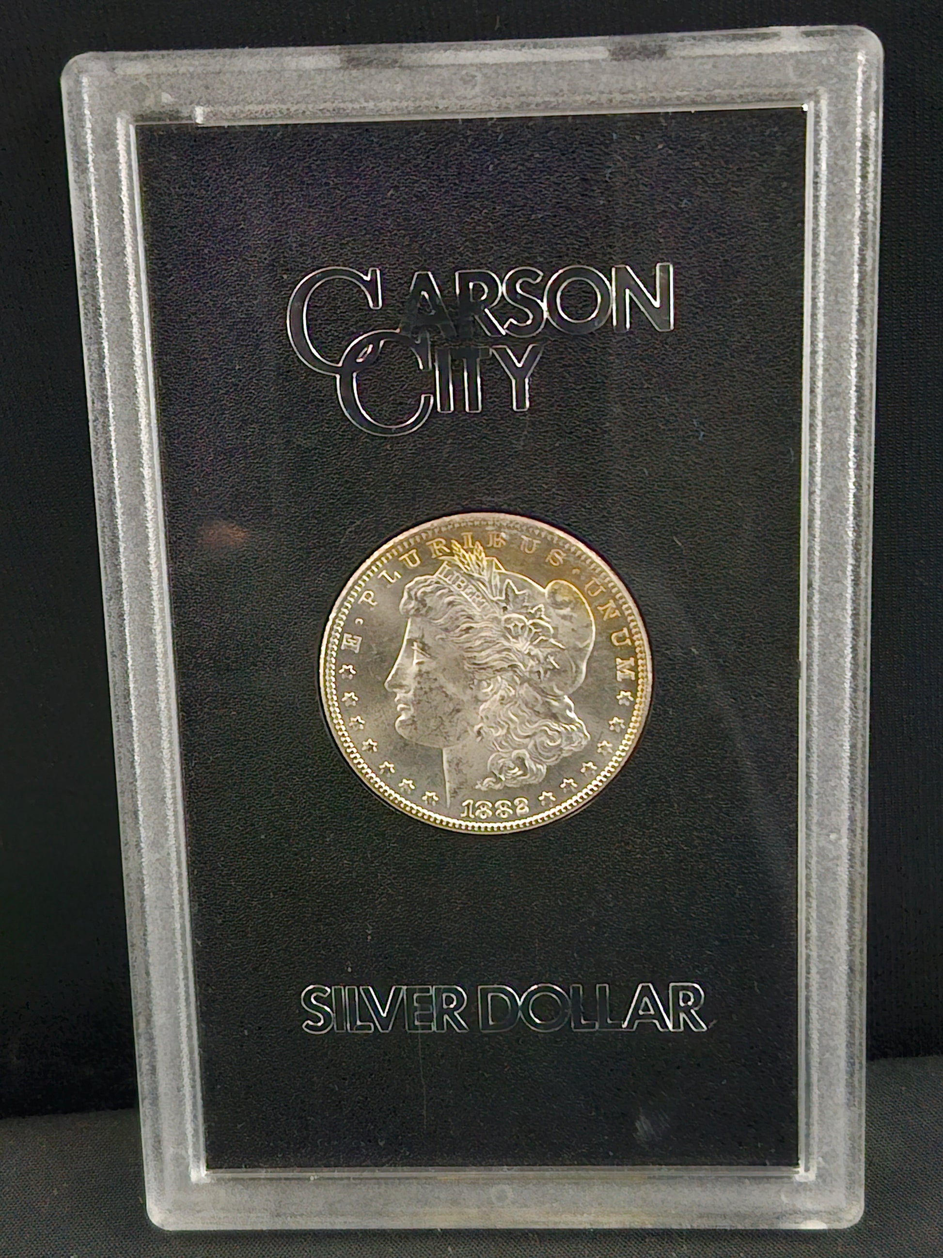 Silver coin in a Carson City holder on a black background