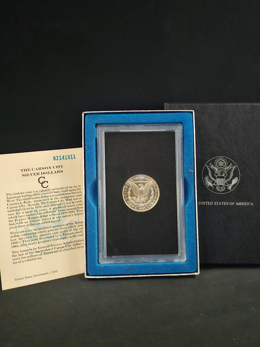 Silver coin in a display case with a certificate on a dark background