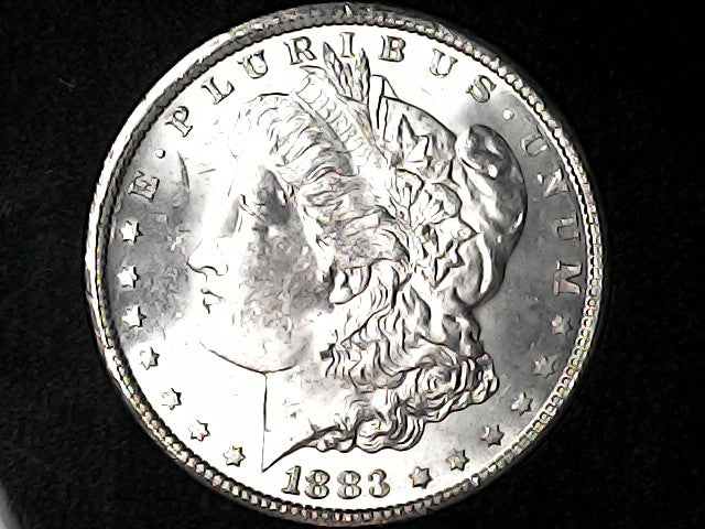 Morgan silver dollar coin with 'Liberty' head and 'E Pluribus Unum' inscription on a black background