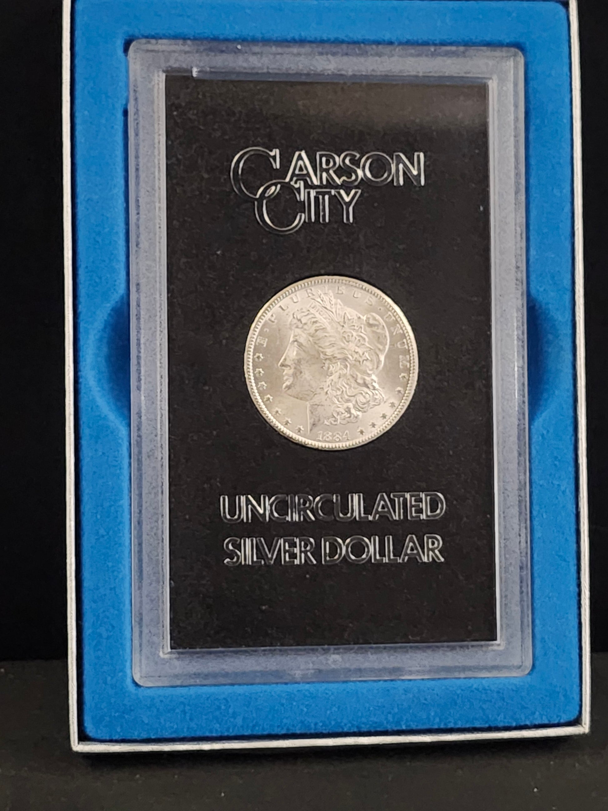 Silver coin in a Carson City holder on a black background