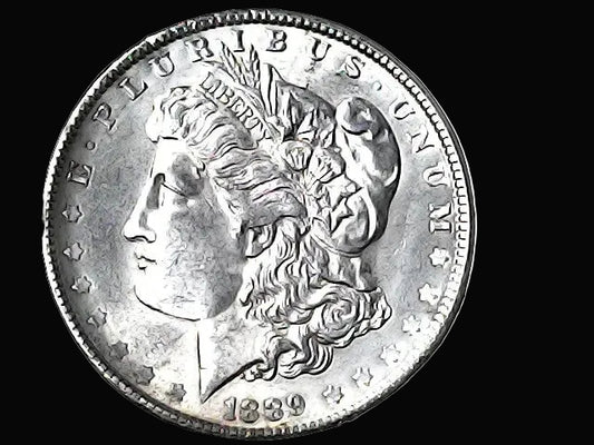 Silver Morgan Dollar with 'E Pluribus Unum', 'Liberty'  and '1889' inscriptions on a black background