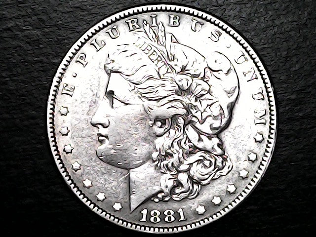 Silver Morgan dollar coin with Liberty head on a dark background