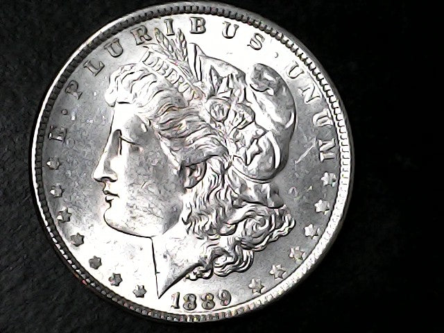 Silver Morgan Dollar with 'E Pluribus Unum', 'Liberty'  and '1889' inscriptions on a black background