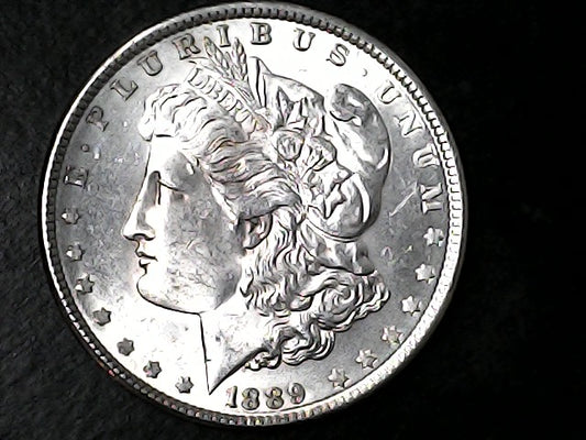 Silver Morgan Dollar with 'E Pluribus Unum', 'Liberty'  and '1889' inscriptions on a black background